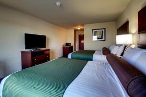 a hotel room with a bed and a television at Cobblestone Inn & Suites - Rugby in Rugby