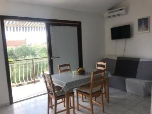 a dining room with a table and chairs and a balcony at Apartmani Vilma Pakoštane in Pakoštane