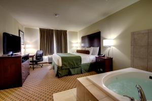 a hotel room with a large tub and a television at Cobblestone Inn & Suites - Rugby in Rugby