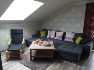 ein Wohnzimmer mit einem blauen Sofa und einem Tisch in der Unterkunft Ferienwohnung Steinbeisser in Arrach
