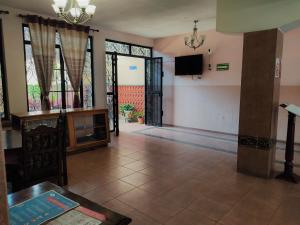 een lege woonkamer met een tv en een tafel bij Hotel Casa La Gran Señora in Tequila