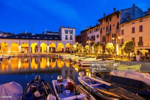 a group of boats docked in a canal with buildings at APPARTAMENTO LAKE GARDA ibiscus di Francia in Desenzano del Garda