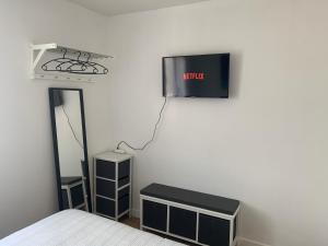 1 dormitorio con 1 cama y TV en la pared en Villa des Palmiers, Chambre 3, Lit double, en Villeneuve-sur-Lot