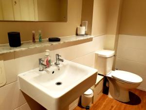 uma casa de banho com um lavatório branco e um WC. em The Pelican Inn em Devizes