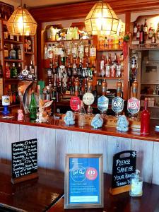 a bar with a counter with a lot of alcohol at The Pelican Inn in Devizes