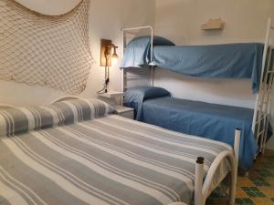 普爾薩諾的住宿－Locazione turistica Le Vele，一间卧室配有两张双层床,铺有蓝色床单。