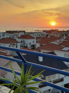 een balkon met uitzicht op de stad bij zonsondergang bij Av. 1º de Maio in Costa da Caparica