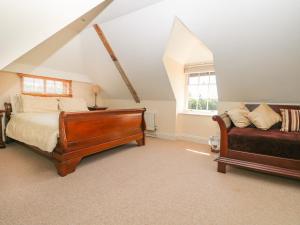 ein Schlafzimmer mit einem Bett und einem Sofa in der Unterkunft Groomes Country House in Bordon