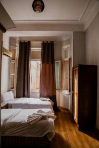 een slaapkamer met 2 bedden en een raam bij My Hotel in Caïro