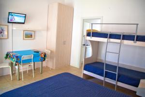 a bedroom with bunk beds with a table and a desk at Residence Casabianca in Porto San Giorgio