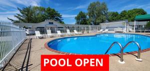 a pool with a pool open sign next to it at Glass House Inn Erie Near I-90 & I-79 in Erie