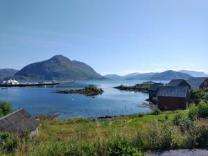 una vista de un cuerpo de agua con casas y montañas en Leinastova, en Sandshamn