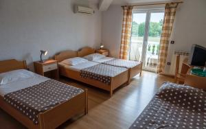 a hotel room with two beds and a balcony at Guesthouse Palombaro in Umag