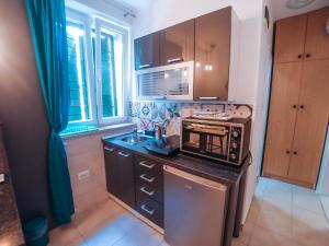 a small kitchen with a stove and a sink at Julije Rooms in Split