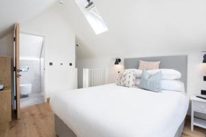- une chambre blanche avec un grand lit et une salle de bains dans l'établissement Warehouse Holiday Lets, à Whitstable