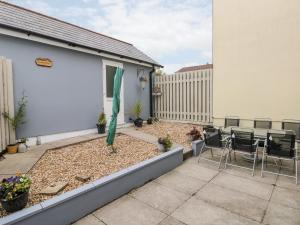 un patio con mesa y sillas en un patio trasero en Sandy Bay House, en Saundersfoot