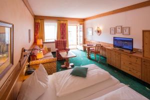 a living room with a bed and a television at Hotel Zum Schwarzen Bären in Emmersdorf an der Donau