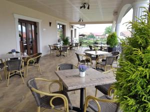 an empty patio with tables and chairs in a restaurant at Equinoxe Royal Reghin in Reghin