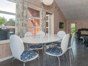 ロモ・キルケビーにあるHoliday home Rømø XXVIIIのダイニングルーム(白いテーブル、椅子付)