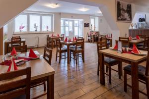 a restaurant with tables and chairs with red napkins on them at Penzion Lihovar *** in Rouchovany