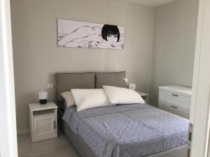 1 dormitorio con 1 cama y una foto en la pared en Rosso Tramonto luxury-white- LADISPOLI, Lungomare Regina Elena 58 en Ladispoli