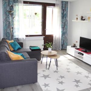 uma sala de estar com um sofá e uma mesa em Bright star apartament Siilinjärvi em Siilinjärvi