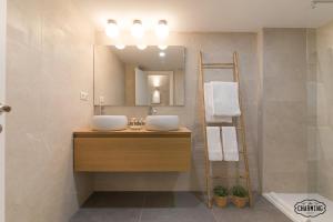 Baño con 2 lavabos y espejo en Charming Museo del Prado II - Estancias Temporales, en Madrid