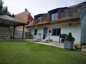 a yard with two chairs and a house at VeleLak in Velence