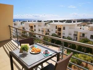 una mesa con un plato de comida en el balcón en Sunny Apartment with sea view in Albufeira, en Albufeira