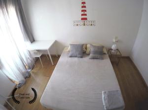 uma grande cama branca num quarto com uma janela em Aveiro Guest House em Aveiro