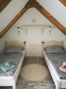 two beds in a attic room with a table at VeleLak in Velence