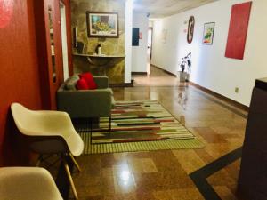 ein Wohnzimmer mit Stühlen und einem Teppich auf dem Boden in der Unterkunft Hotel Cambará - By UP Hotel in Osasco