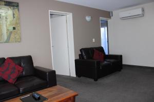 uma sala de estar com duas cadeiras de couro preto e uma mesa em Gladstone Motel em Richmond