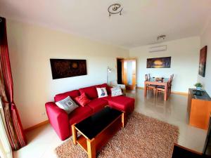 sala de estar con sofá rojo y mesa en Sunny Apartment with sea view in Albufeira, en Albufeira