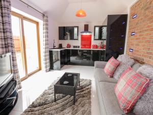 a living room with a couch and a kitchen at Smithy Cottage in Cemaes Bay +5 photos