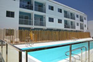 a swimming pool in front of a building at La Perla de Sunset Beach in Corralejo