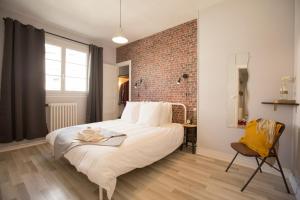 une chambre avec un grand lit et un mur de briques dans l'établissement #LIndustrioChampetre Free Parking, Bien Situé, Spacieux, Proche Clinique, à Rouen
