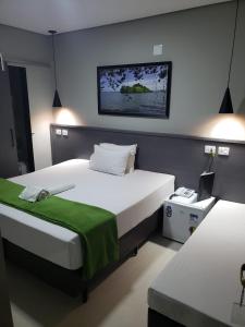 a bedroom with two beds and a laptop on a table at Hotel Recanto das Perdizes in Sao Paulo