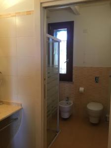 a bathroom with a toilet and a glass shower at Borgo della Luna in Birgi Vecchi