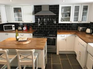 a kitchen with white cabinets and a wooden counter top at The Old Vicarage in Looe
