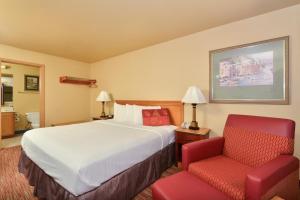 a hotel room with a bed and a chair at Americas Best Value Inn Lakewood South Tacoma in Lakewood