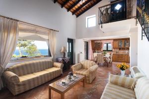 a living room with two couches and a table at VILLA AVLOS in Monemvasia