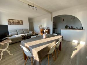 a living room with a table and chairs and a couch at Magnifique appartement devant la plage in Propriano