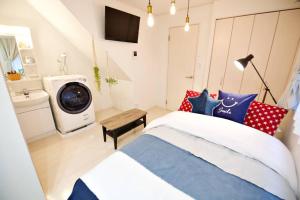 - une chambre avec un lit et un lave-linge dans l'établissement R-Guest Residence 東京浅草 east2, à Tokyo