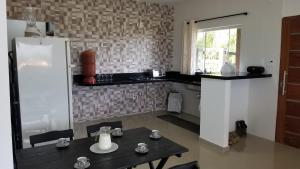 a kitchen with a table and a refrigerator at Casa Bela Vista in Penedo