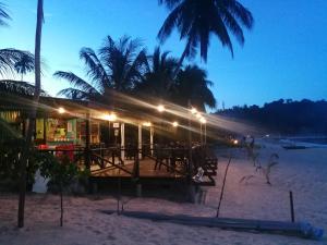 a restaurant on the beach at night at Rainbow Tioman Cottage in Kampong Juara
