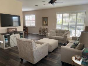 a living room with couches and a flat screen tv at Cozy Villa With South Facing Pool in Davenport