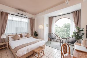 a bedroom with a large bed and a large window at Muan Hotel in Chiang Mai