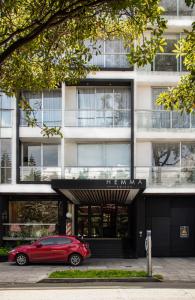 un coche rojo estacionado frente a un edificio en Hemma Bogotá Luxury Suites Hotel en Bogotá