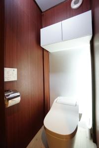 a bathroom with a toilet and a wooden wall at From Scratch Hanare in Tokyo